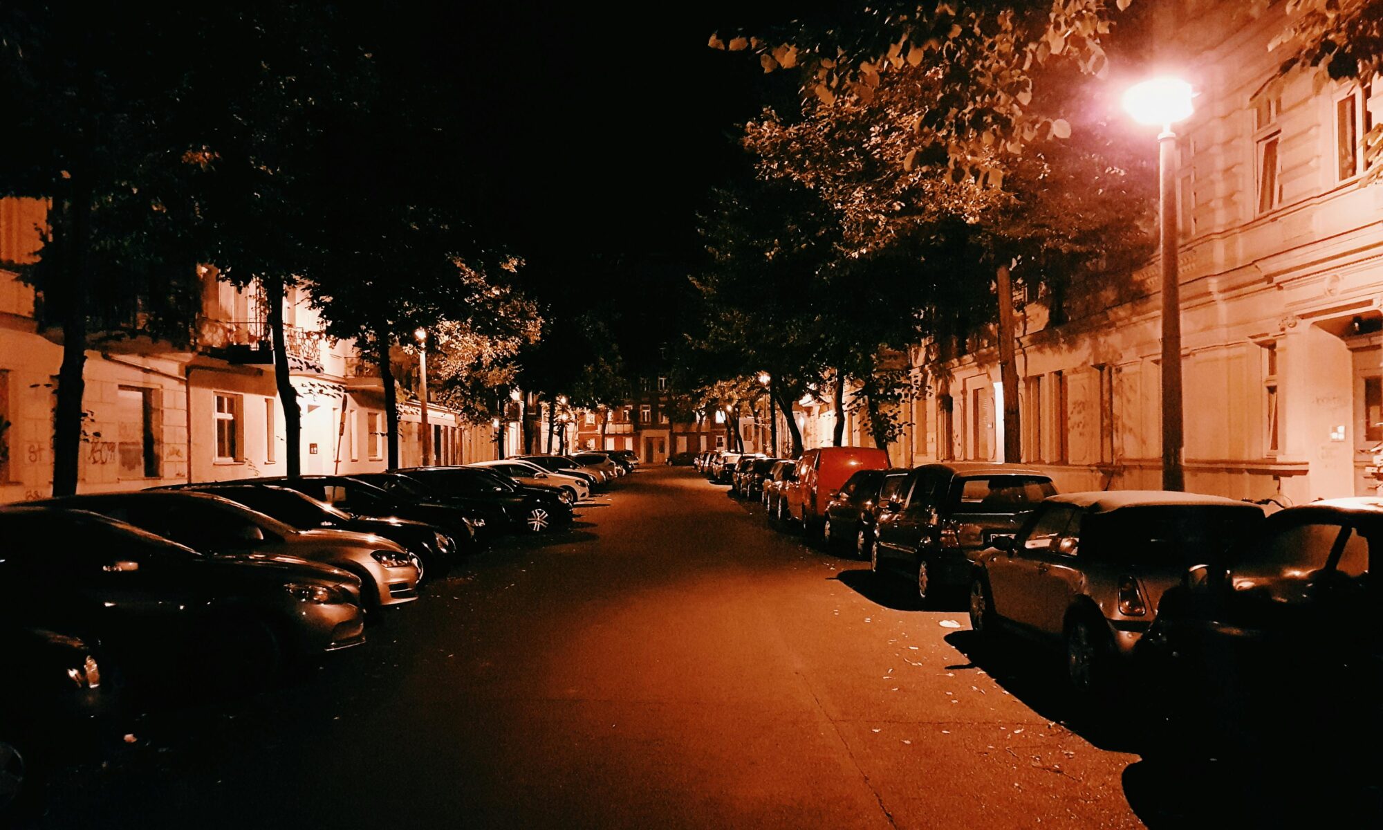 Eine Berliner Straße im warmen Laternenlicht.